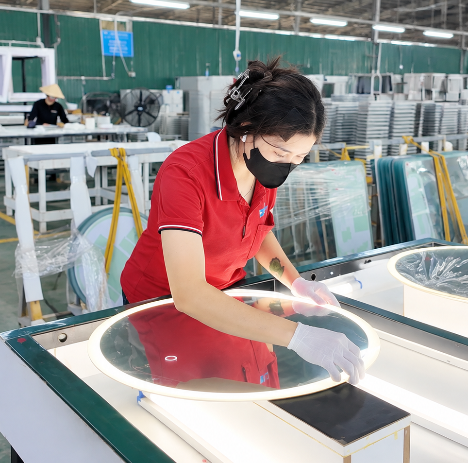 Worker inspecting an LED mirror during production at the factory